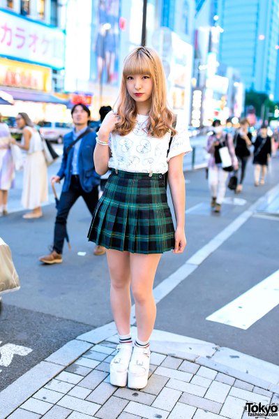 white graphic t-shirt with green and black checked mini pleated skirt