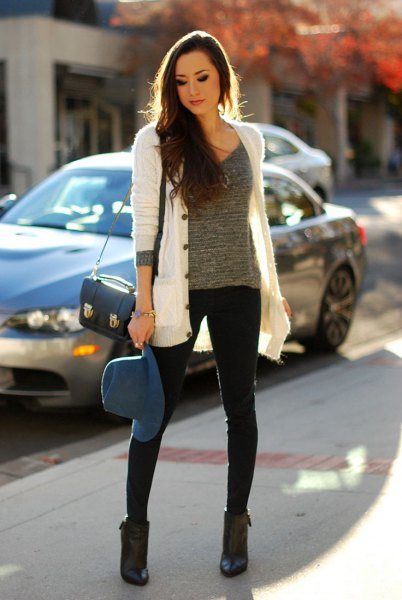white cardigan with gray knitted sweater with scoop neckline and black skinny jeans