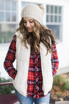 white knitted hat with a red and black checked shirt and light blue jeans