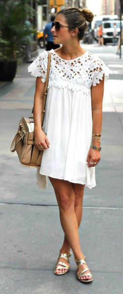 Pleated swing mini dress made of white lace with cap sleeves and golden strappy sandals