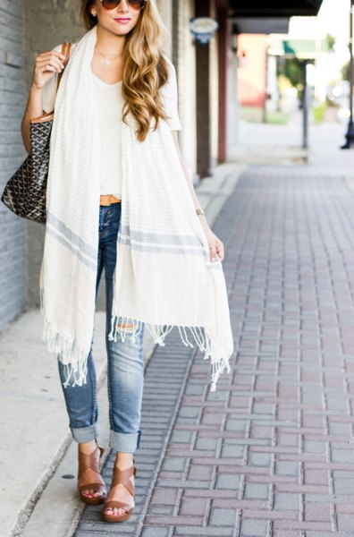 white long fringed scarf with white, short cut T-shirt and blue jeans with cuffs