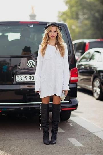 white long-sleeved dress with black felt hat and leather boots