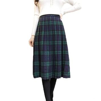 white long-sleeved sweater with green and dark blue midi plaid skirt