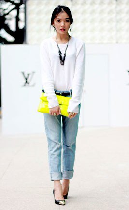 white long-sleeved T-shirt with light blue jeans with cuffs and yellow clutch