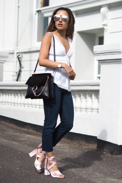 white sleeveless top with a low cut and open toe heels made of silver velvet