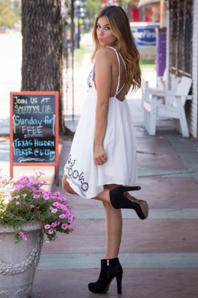 white midi babydoll dress with open back and black suede boots