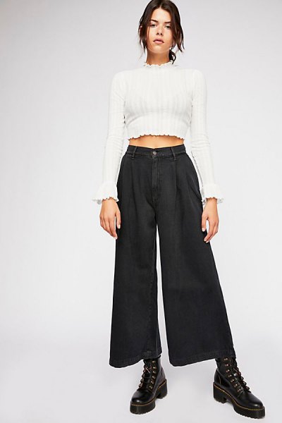 white, short cut sweater with mock neck and black pleated jeans