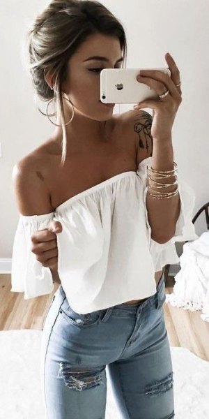 Off-the-shoulder evening top in white with light blue skinny jeans