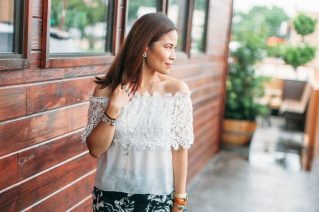 Off-the-shoulder, semi-transparent top made of lace and chiffon with a black skirt with a floral pattern
