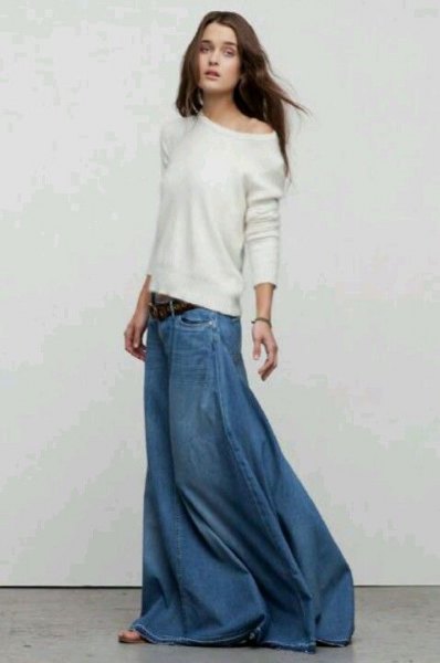 white sweater with one shoulder and a loose fit and floor-length denim skirt