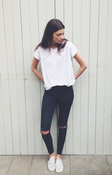 white oversized t-shirt with black ankle-ripped jeans and canvas sneakers