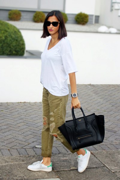 white oversized t-shirt with green ripped khaki jeans