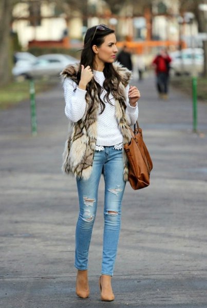 white sweater with faux fur vest and light blue skinny jeans
