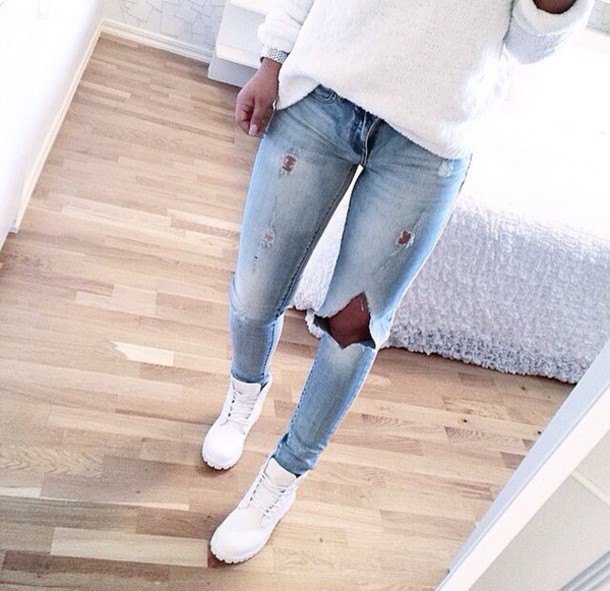 white knitted sweater with a loose fit, light blue jeans and boots