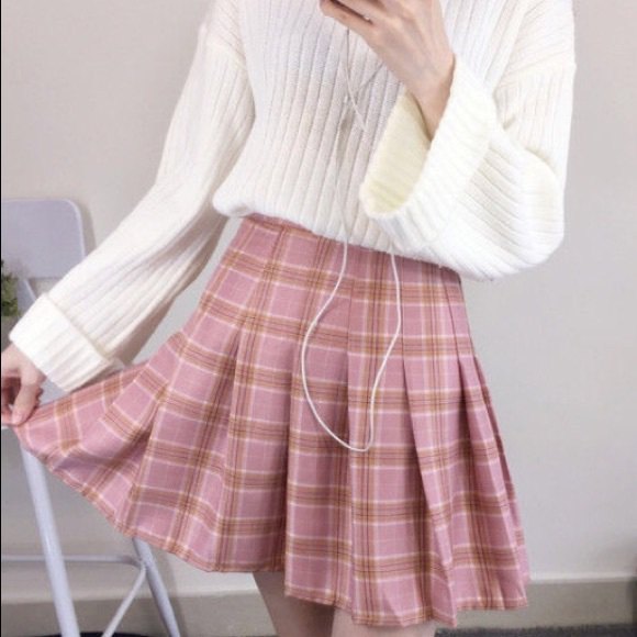 white ribbed knitted sweater with a red, pleated, checked mini skirt