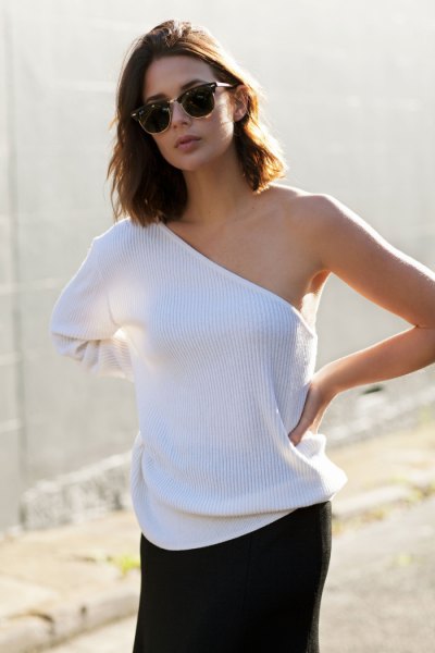 white ribbed sweater with one shoulder and black mini skirt