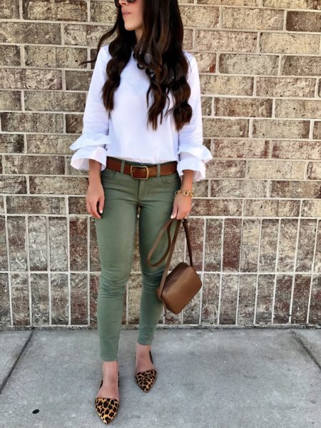 white blouse with ruffle sleeves and olive-colored skinny jeans
