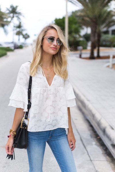 Oversized blouse with white ruffle sleeves and light blue skinny jeans