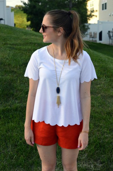 white t-shirt with scalloped hem and orange mini-shorts