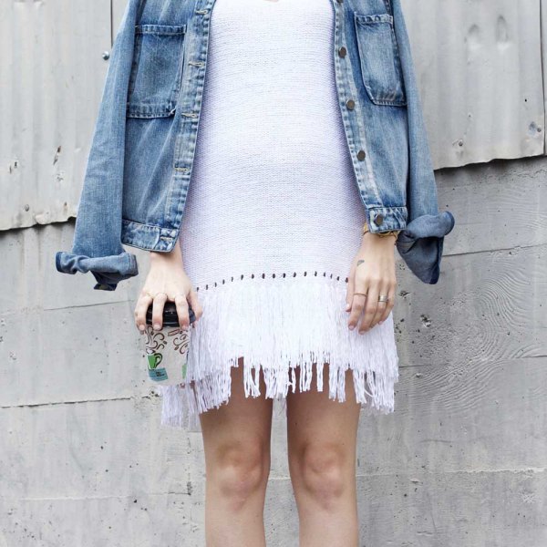 white denim jacket with a shift dress over the shoulders