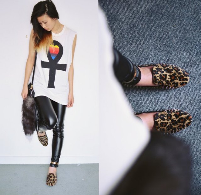 white sleeveless graphic t-shirt with black leather gaiters and leopard print slippers