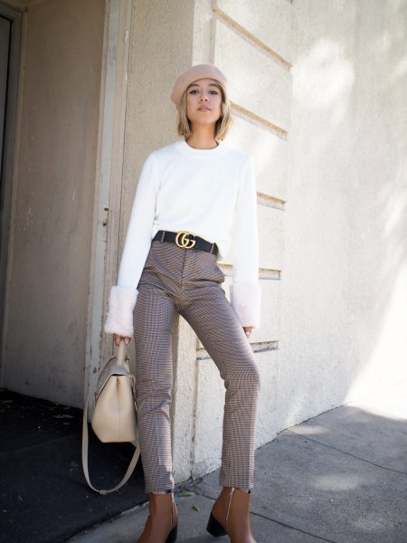 white sweater with a light pink painter's hat and statement belt