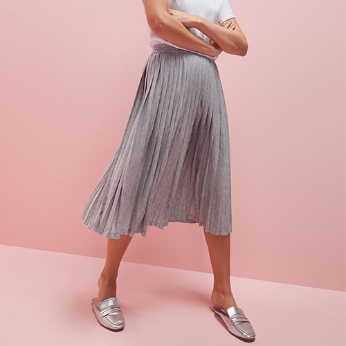white t-shirt with a light gray pleated skirt and silver evening shoes