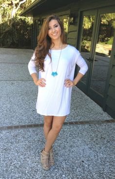 white tunic dress with three-quarter sleeves and bare strappy sandals