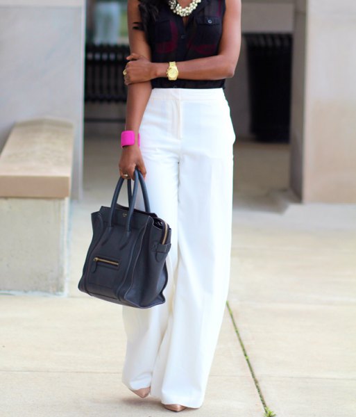 white pants with black sleeveless blouse and statement chain