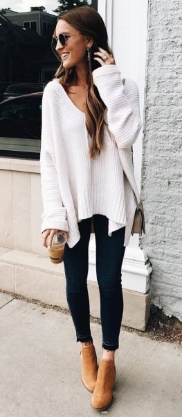 white, chunky autumn sweater with V-neck and black-cut skinny jeans