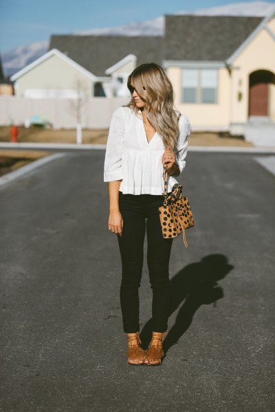 white peplum blouse with V-neckline and black sleeves and black skinny jeans