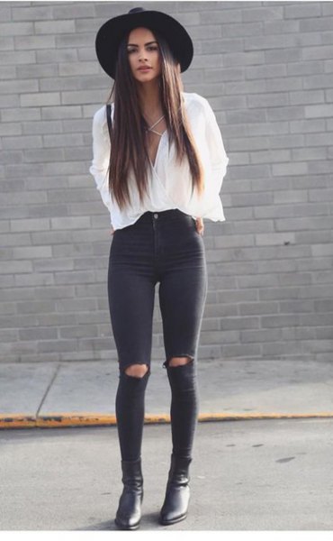 white blouse with V-neck and black skinny jeans with a tear in the knee