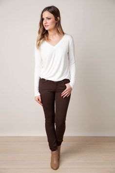 white long-sleeved V-neck t-shirt, brown jeans and ankle boots