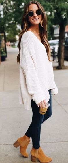 white oversized V-neck sweater and suede ankle boots with camel heel