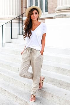 white V-neck shirt and light pink linen pants with an elastic waist