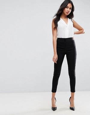 white sleeveless blouse with V-neckline and black, narrow-cut trousers