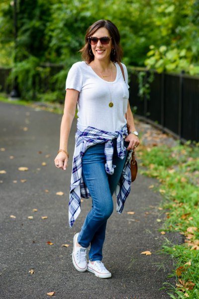 white V-neck t-shirt, jeans and blue plaid shirt tied around the waist