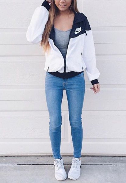 white windbreaker with gray, figure-hugging tank top and blue skinny jeans