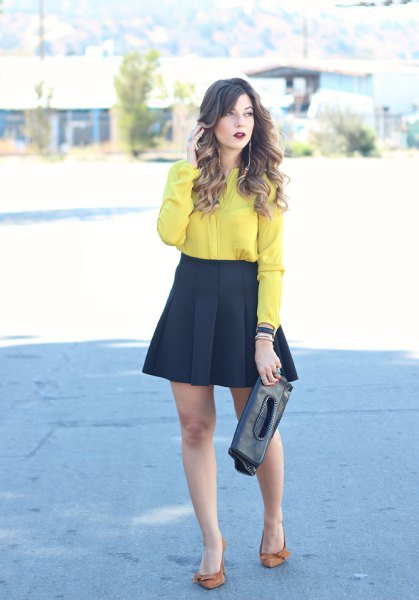yellow shirt with buttons and black, flared mini and pleated skirt