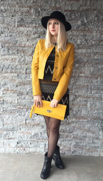 yellow leather jacket, black sheath dress printed with tribal
