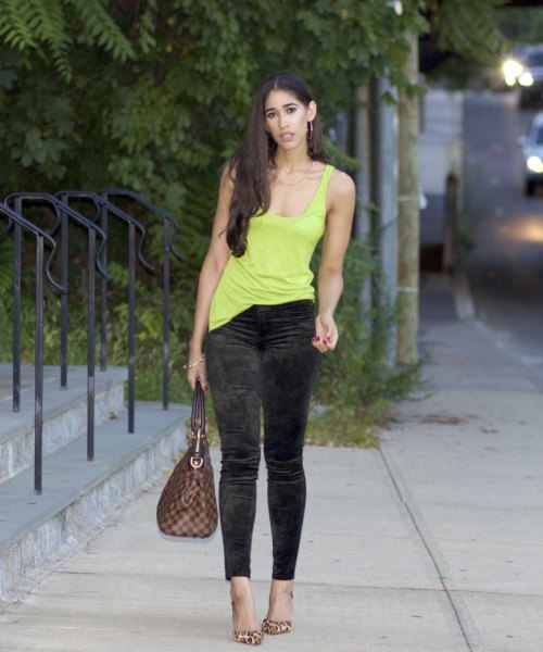 yellow tank top with deep scoop neckline and narrow pants made of black velvet with ankles