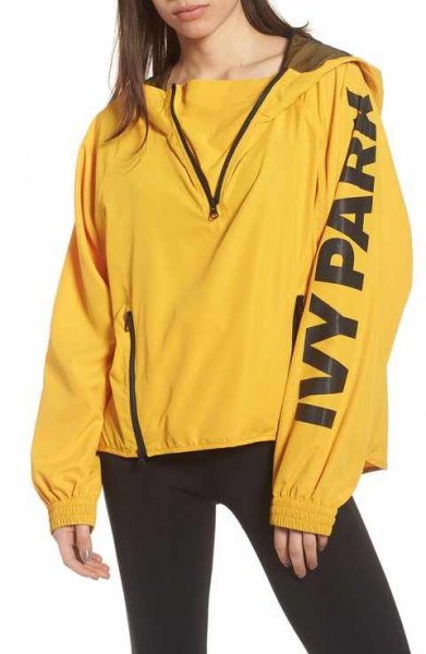 yellow windbreaker with sweater and black running shorts