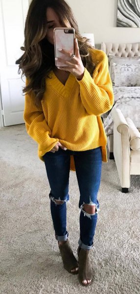 Yellow coarse knit sweater with V-neck and blue skinny jeans